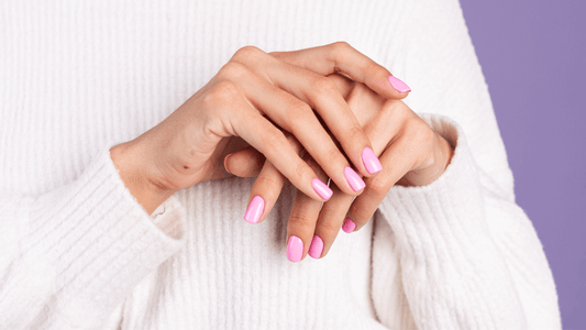 Mains de femmes portant des faux ongles roses