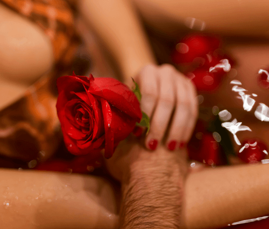 Une femme et un homme tenant une rose dans l'eau pour représenter une collection de faux ongles pour la saint Valentin