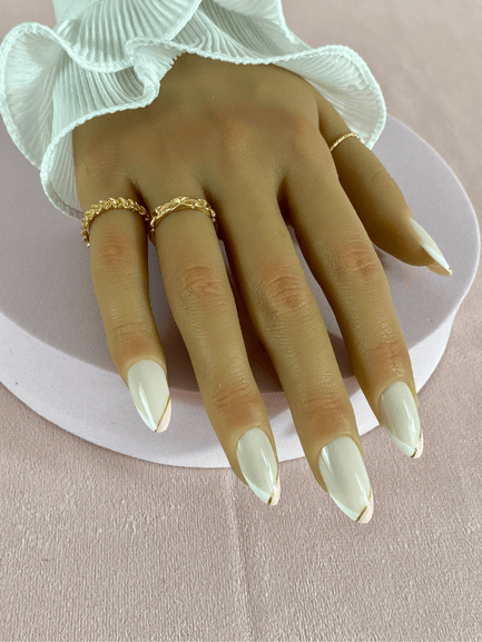 Kit de faux ongles réutilisables avec des designs variés, incluant des French manucure de deux couleurs qui sont le blanc et rose clair terminant par une ligne d'or, la forme des ongles est amande.