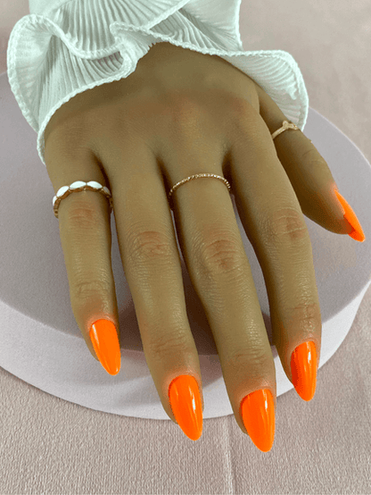 Faux ongles réutilisables, couleur orange fluo, en forme d'amande et finition brillante.