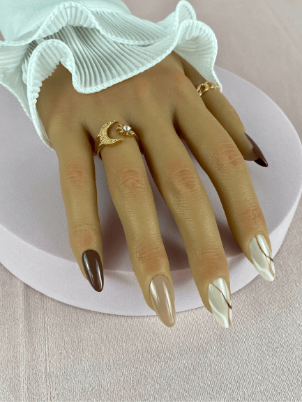 Faux ongles réutilisables, marron et longs, forme amande avec deux nailart abstraits des lignes marron et blanc, pour une manucure audacieuse et chic.