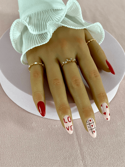 Ensemble de faux ongles réutilisables avec des motifs morpion, petit coeurs rouges et une inscription "love", de forme amande.