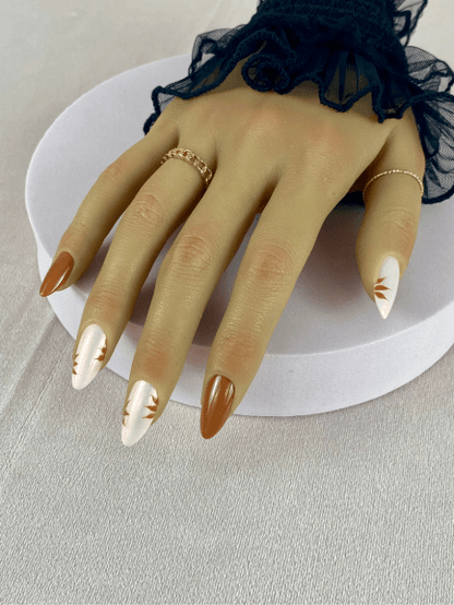 Ensemble de faux ongles réutilisables pour cet automne avec des feuilles couleur caramel et effet chrome rose, en forme de amande, pour un style moderne et glamour.