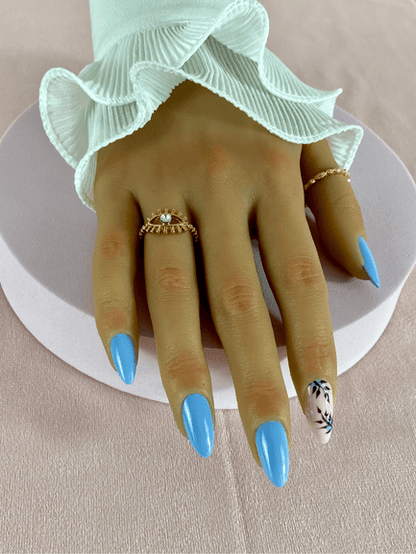 Ensemble de faux ongles réutilisables, de couleur bleu clair, avec un nail art aux motifs floraux et des formes abstraites
