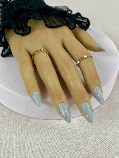 Kit de faux ongles réutilisables avec des designs variés, incluant des motifs flocons de neiges et des étoiles, parfait pour accompagner vos tenues de Noël.