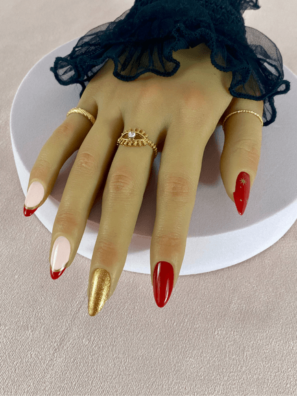 Kit de faux ongles réutilisables à coller avec des adhésifs avec des designs variés, incluant une French manucure rouge et or, des étoiles or et un doigt or brillant.