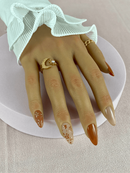 Faux ongles réutilisables, couleur nude, caramel, en forme d'amande, avec un fini brillant et nailart floral pour un look automnale et naturel.