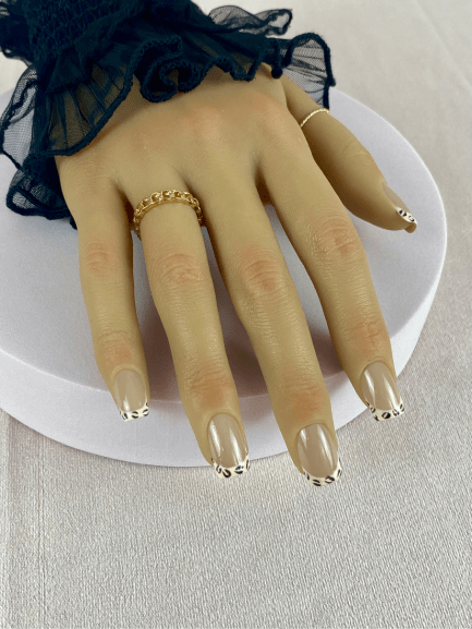 Kit de faux ongles réutilisables avec des designs variés, incluant des motifs en French manucure léopard et des paillettes, pour un style élégant et tendance.