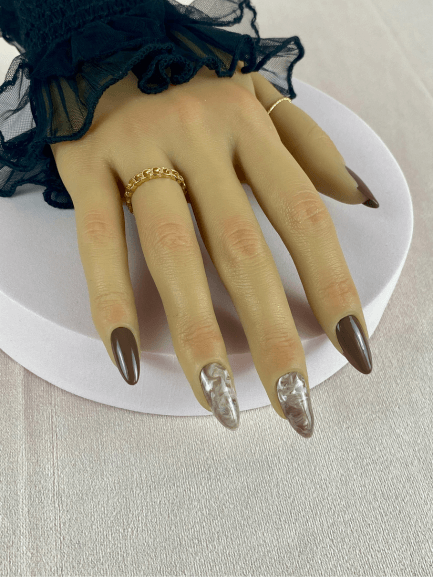 Faux ongles réutilisables, marron et longs, avec un effet marbre marron et blanc pour une manucure audacieuse et chic.