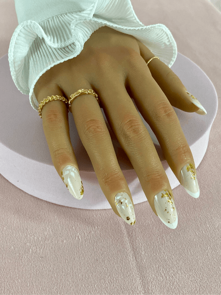 Kit de faux ongles réutilisables avec des designs variés, incluant des motifs floraux, French manucure blanche et des feuilles d'or, pour un style à adopter lors d'un mariage.
