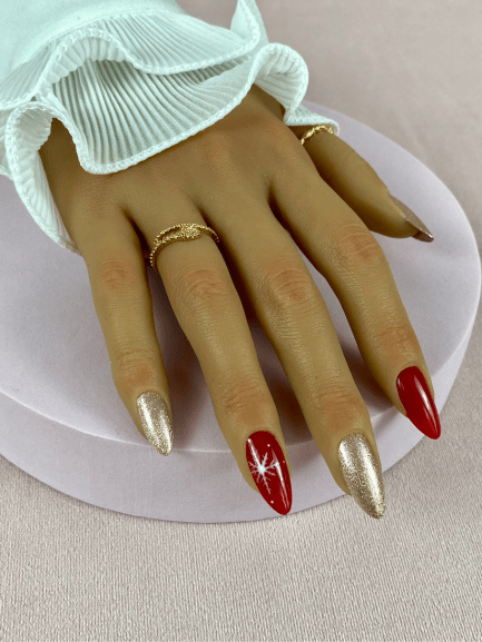 Faux ongles réutilisables, rouges et longs, avec un nail art de noel pour une manucure audacieuse et chic.