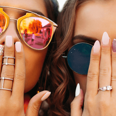 Groupe de femmes avec des lunettes de soleil, les mains devant la bouches et des manucures avec nail art